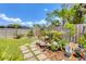 Landscaped backyard features a charming water feature surrounded by colorful flowers and lush greenery at 5879 Venisota Rd, Venice, FL 34293