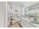 Bright bathroom features a white vanity with drawers and a modern sink, complemented by neutral tile flooring at 5879 Venisota Rd, Venice, FL 34293