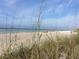 Beautiful Manasota Beach view with white sand, blue water, and beachgoers relaxing in the sun at 5879 Venisota Rd, Venice, FL 34293