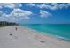 Beautiful Gulf view, soft sand beach, and clear blue skies creating a serene beach scene at 5879 Venisota Rd, Venice, FL 34293