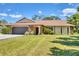 Charming single-story home featuring a well-manicured lawn, a stone-accented facade, and an attached two-car garage at 5879 Venisota Rd, Venice, FL 34293