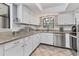 Well-lit kitchen featuring stainless steel appliances, granite countertops, and white cabinetry at 5879 Venisota Rd, Venice, FL 34293