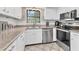 Kitchen with stainless steel appliances, granite countertops, and ample white cabinet storage at 5879 Venisota Rd, Venice, FL 34293
