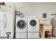 Functional laundry room with modern washer, dryer, and utility sink, ideal for efficient home management at 5879 Venisota Rd, Venice, FL 34293
