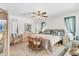 Bright main bedroom with neutral decor, tile flooring, ceiling fan, and natural light from the windows at 5879 Venisota Rd, Venice, FL 34293