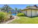A screened-in pool features a lush landscaped perimeter with a stepping stone walkway to the home at 5879 Venisota Rd, Venice, FL 34293