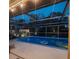 Inviting screened pool area offers a refreshing retreat, illuminated by ambient lighting for evening swims at 5879 Venisota Rd, Venice, FL 34293