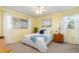 Inviting bedroom with yellow walls, bright white bedding, and ample natural light at 708 Tamiami S Trl # 216, Venice, FL 34285