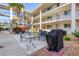 Community courtyard featuring outdoor seating and a barbecue grill at 708 Tamiami S Trl # 216, Venice, FL 34285