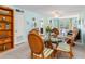 Dining room with a round glass table with seating for four, bright walls, and an adjacent living area at 708 Tamiami S Trl # 216, Venice, FL 34285