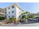 Exterior of condo showcasing well-maintained landscaping and covered parking at 708 Tamiami S Trl # 216, Venice, FL 34285