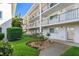 Condo exterior featuring well-maintained landscaping, a small bench, and black railings at 708 Tamiami S Trl # 216, Venice, FL 34285