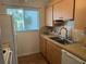 Efficient kitchen featuring wood cabinets, white appliances, and a stainless steel faucet at 708 Tamiami S Trl # 216, Venice, FL 34285