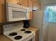 Cozy kitchen featuring white appliances, wood cabinets, and ample counter space near a bright window at 708 Tamiami S Trl # 216, Venice, FL 34285