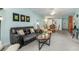Open-concept living room showcasing a large sofa, cozy chairs, a dining area, and neutral-colored carpet at 708 Tamiami S Trl # 216, Venice, FL 34285