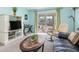 Inviting living room with sliding door to a balcony, black sofa, and neutral-colored carpet at 708 Tamiami S Trl # 216, Venice, FL 34285