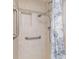Updated shower with tiled walls, built-in niche, and grab bars for safety at 708 Tamiami S Trl # 216, Venice, FL 34285