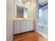 A bathroom with hardwood floors, a sink, vanity, a mirror, a shower and a toilet at 7180 Quarry St, Englewood, FL 34224