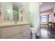 Bright bathroom featuring a single sink vanity and toilet with a view of a window seat and table at 7180 Quarry St, Englewood, FL 34224
