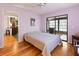 A bedroom with hardwood floors, a sliding glass door to the screened patio, and neutral colored walls at 7180 Quarry St, Englewood, FL 34224