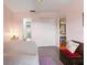 Cozy bedroom with light pink walls and a gray tile floor featuring a seating area and view to other rooms at 7180 Quarry St, Englewood, FL 34224