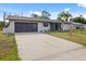 Charming single-story home with a spacious driveway and attached garage on a sunny day at 7180 Quarry St, Englewood, FL 34224