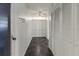 Hallway featuring white walls, gray tile floor, ceiling fan and multiple closet doors at 7180 Quarry St, Englewood, FL 34224