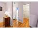 A hallway with hardwood floors leading to a bathroom with shower and walk in closet at 7180 Quarry St, Englewood, FL 34224