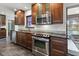A kitchen showcasing wood cabinets, stainless steel appliances, granite countertops, and access to the patio at 7180 Quarry St, Englewood, FL 34224