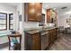 A kitchen featuring dark wood cabinets, granite countertops, stainless steel appliances, and a dining area at 7180 Quarry St, Englewood, FL 34224
