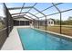 Large, screened-in pool with views of the home and backyard at 7180 Quarry St, Englewood, FL 34224