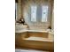 Bathroom featuring a tile tub, floral wallpaper, and unique vintage windows at 786 Heathercreek Ct, Englewood, FL 34223