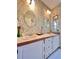Bathroom with dual sinks, vanity, and ornate wallpaper at 786 Heathercreek Ct, Englewood, FL 34223
