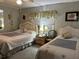 Charming bedroom features two beds with wicker headboards, complemented by a side table with lamps at 786 Heathercreek Ct, Englewood, FL 34223