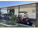 Carport view with a golf cart and a car parked under a covered area with support beams at 786 Heathercreek Ct, Englewood, FL 34223
