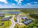Aerial view of a community with a pool, clubhouse, pickleball courts, and picturesque lake at 8244 Shore Lake Dr, Englewood, FL 34224