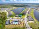 Expansive aerial view of a neighborhood with a lake, pool, clubhouse, playground, and pickleball courts at 8244 Shore Lake Dr, Englewood, FL 34224