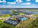 Community aerial view showcasing a pool, clubhouse, playground, pickleball courts, and a scenic lake at 8244 Shore Lake Dr, Englewood, FL 34224