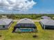Aerial view of screened in pool, backyard with green grass and tropical foliage at 8244 Shore Lake Dr, Englewood, FL 34224