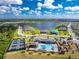 A beautiful aerial view overlooking the community pool, tennis courts, clubhouse, and lake at 8244 Shore Lake Dr, Englewood, FL 34224