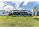 The backyard features a large lawn, landscaping, and a screened-in pool at 8244 Shore Lake Dr, Englewood, FL 34224