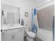 Clean bathroom with a single vanity, tiled shower and tub combination, and framed wall art at 8244 Shore Lake Dr, Englewood, FL 34224