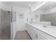 Bathroom featuring dual sinks, white cabinets and a glass-enclosed shower at 8244 Shore Lake Dr, Englewood, FL 34224