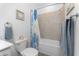 Bathroom with tiled shower and tub combination, floral shower curtain, and stainless steel fixtures at 8244 Shore Lake Dr, Englewood, FL 34224