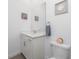 Bathroom featuring a single vanity with grey wood floors and decorative wall art at 8244 Shore Lake Dr, Englewood, FL 34224