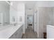 Bright bathroom featuring a quartz countertop vanity and tiled shower with glass enclosure at 8244 Shore Lake Dr, Englewood, FL 34224