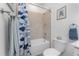 Bathroom with tub and shower combination, blue patterned shower curtain and tiled walls at 8244 Shore Lake Dr, Englewood, FL 34224