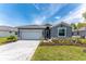 Charming single-story home featuring a paved driveway, well-manicured lawn, and a two car garage at 8244 Shore Lake Dr, Englewood, FL 34224