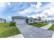 Well-maintained single-story home with a paved driveway, a two-car garage, and pristine landscaping at 8244 Shore Lake Dr, Englewood, FL 34224