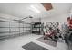 Spacious garage with epoxy flooring, storage racks, workout equipment and a three-car garage door at 8244 Shore Lake Dr, Englewood, FL 34224